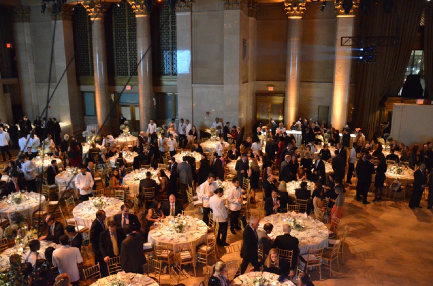 Photo taken from above showing a room with banquet tables and people walking around the tables