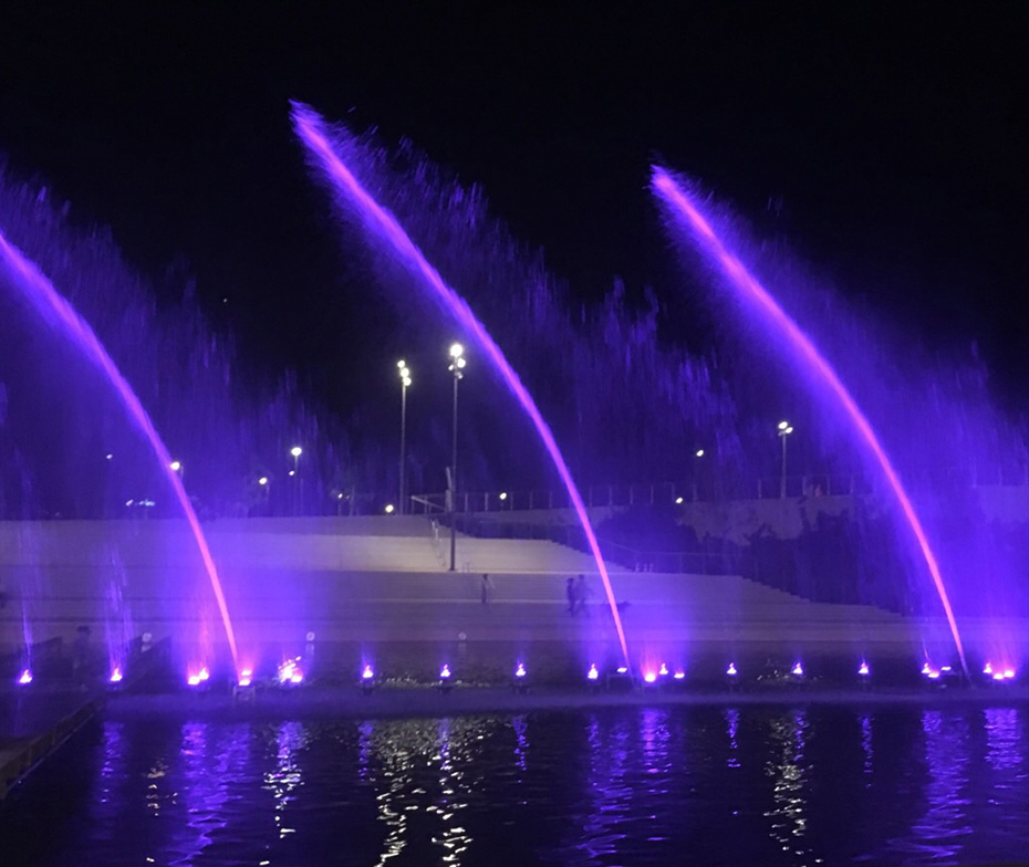 A fountain in the middle of a lake throws its water very high and makes patterns in the air