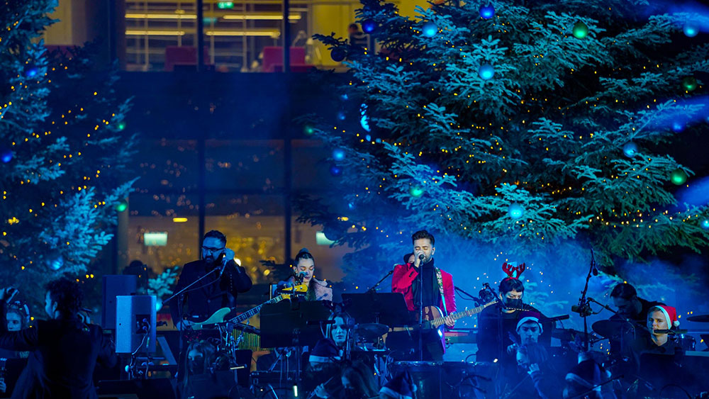 A band plays in front of decorated trees at the Stavros Niarchos Foundation Cultural Center