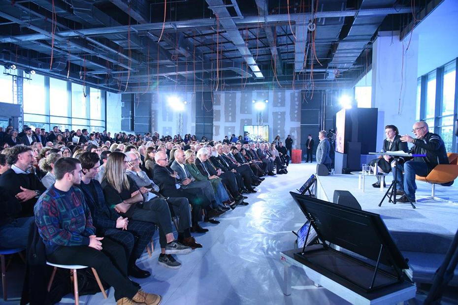 Photo showing the stage where Andreas Dracopoulos, President of the Stavros Niarchos Foundation and Lina Mendoni, Minister of Culture, are sitting and the audience watching them
