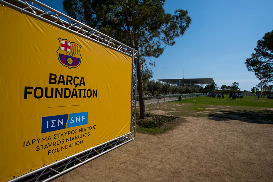 A large banner of the Barca Foundation the Stavros Niarchos Foundation logos outside of the Stavros Niarchos Foundation Cultural Center
