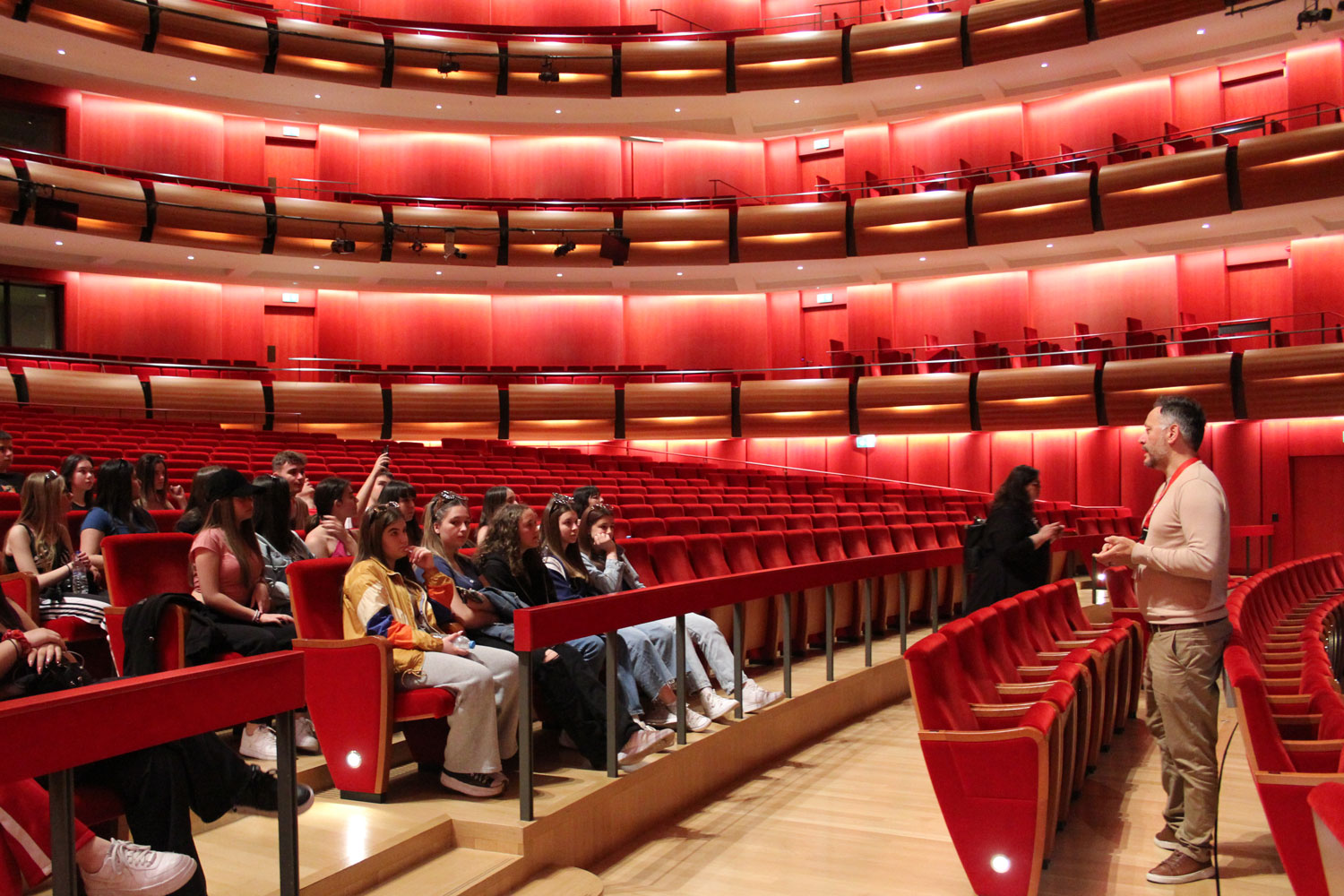 A group of students sit inside the Greek National Opera