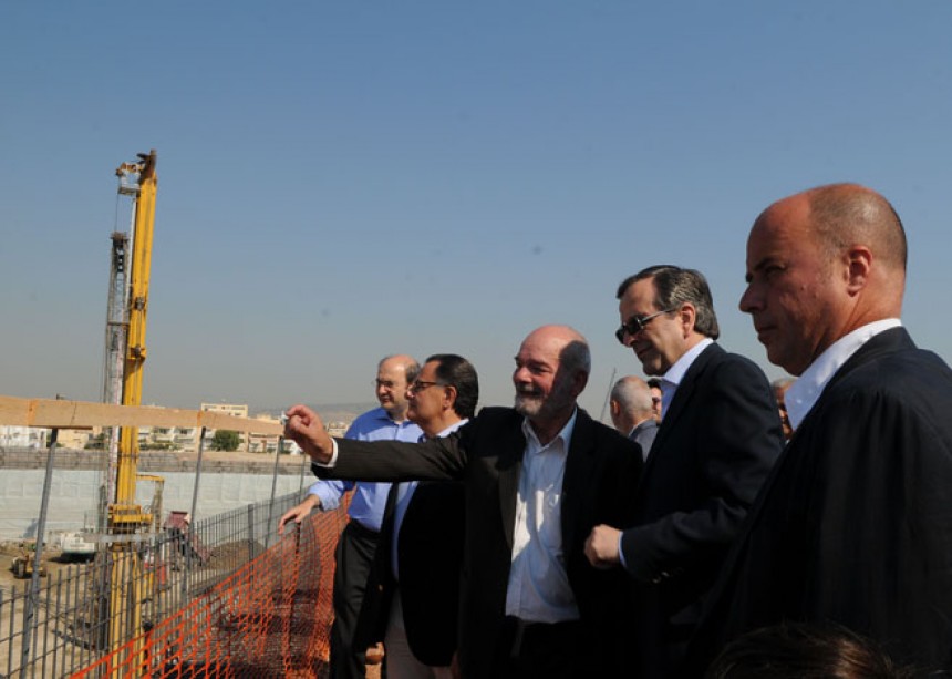 Andreas Dracopoulos, co-president of the Stavros Niarchos Foundation, and Antonis Samaras, the Prime Minister of the Hellenic Republic, look at the view of the construction site of the Stavros Niarchos Foundation Cultural Center with a group of people