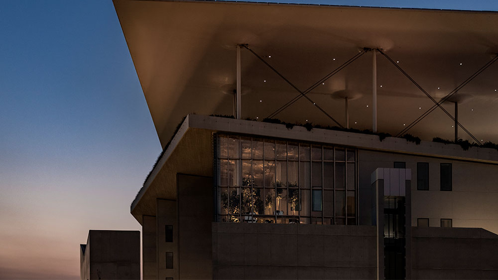 Photo taken at night time showing a large glass window of a building