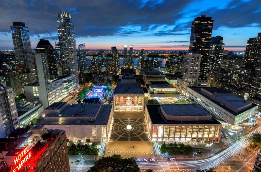 A panoramic view of the Lincoln Center, surrounded by skyscrapers of the New York City.