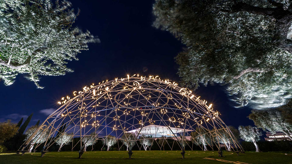 Photograph of an outdoor, semi-circular sculpture with lights at the Stavros Niarchos Foundation Cultural Center