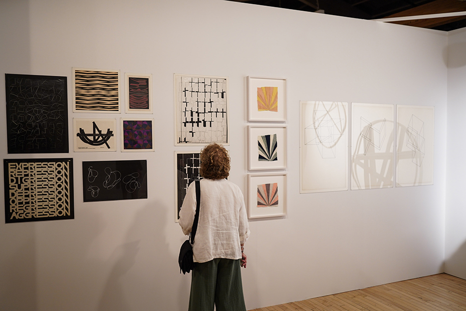 A woman admires a piece of art on the wall in an art exhibition