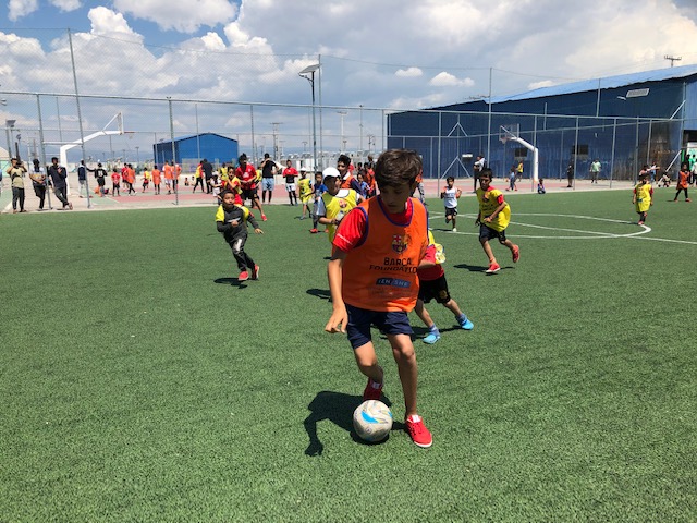A boy has the ball at his feet during a football match