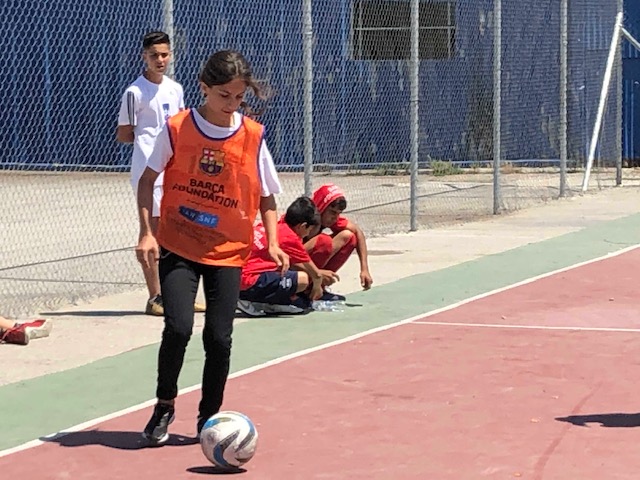 A little girl plays with a soccer ball
