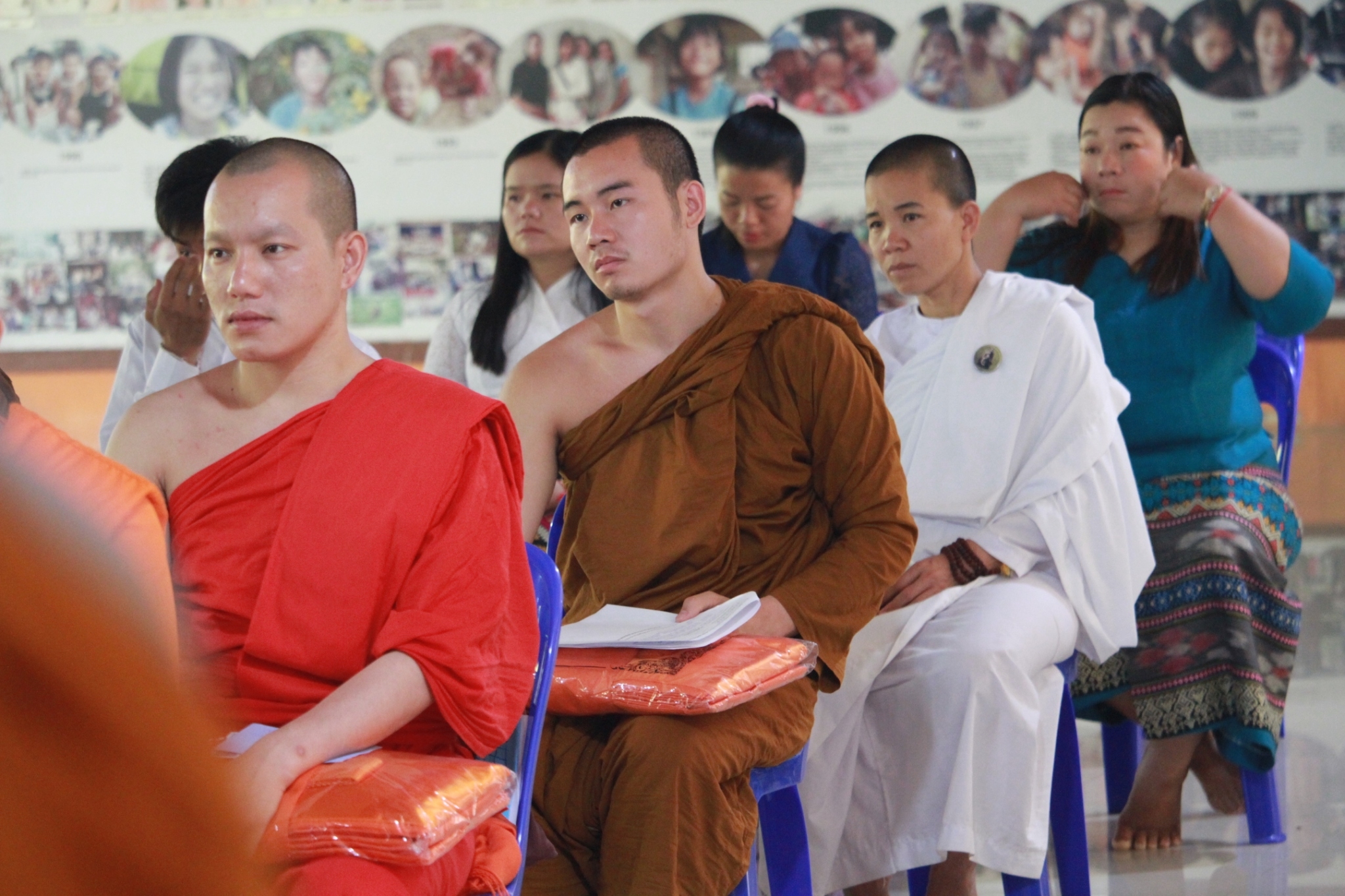 People sit in rows of chairs, attending a presentation.