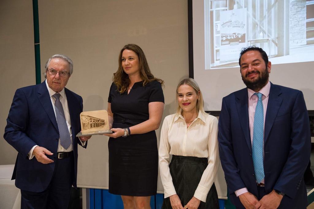 The president of Philekpaideftiki Etaireía, George Babiniotis, awards a plaque to the three representatives of the Stavros Niarchos Foundation (SNF).