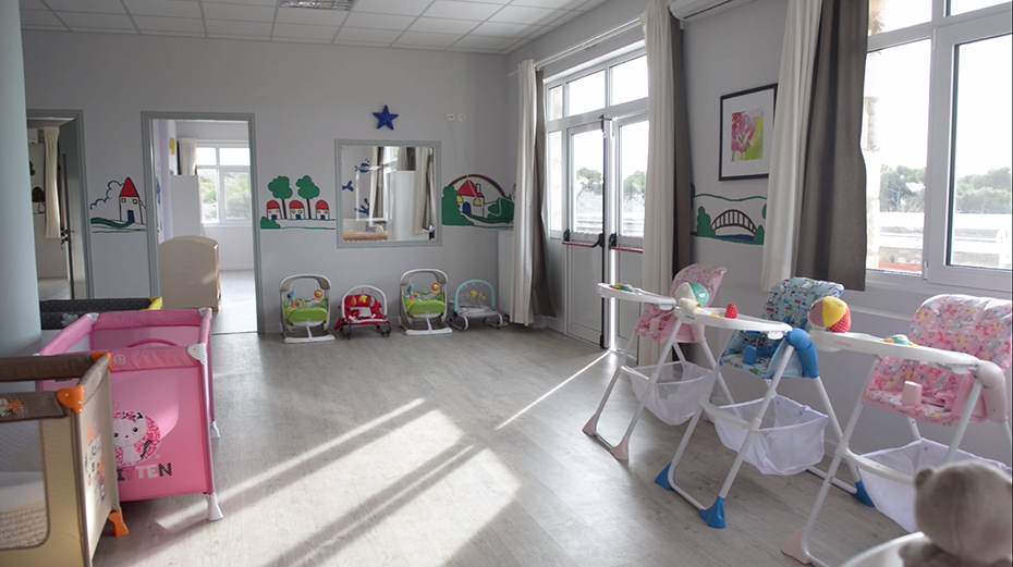 Photo of a baby room in which there are baby cribs and baby seats