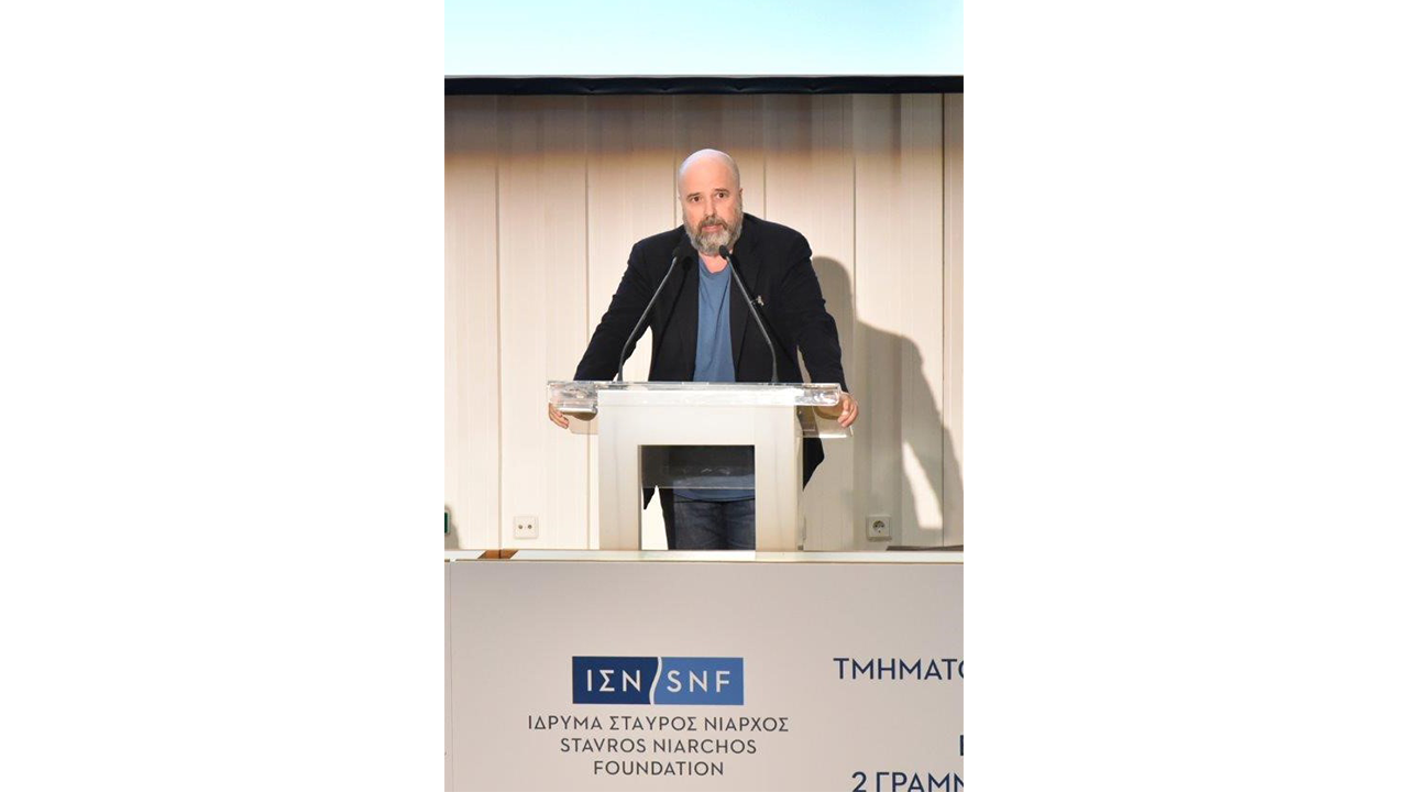 Andreas Dracopoulos, President of the Stavros Niarchos Foundation, stands at the podium and speaks
