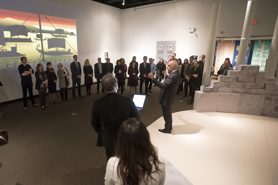 A man speaks to a gathered crowd in a museum