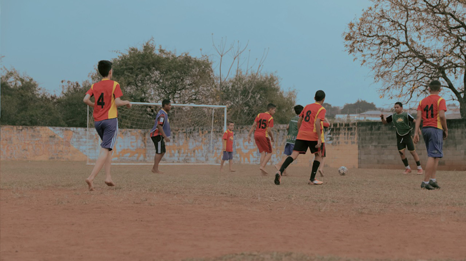A group of children playing football in an arena