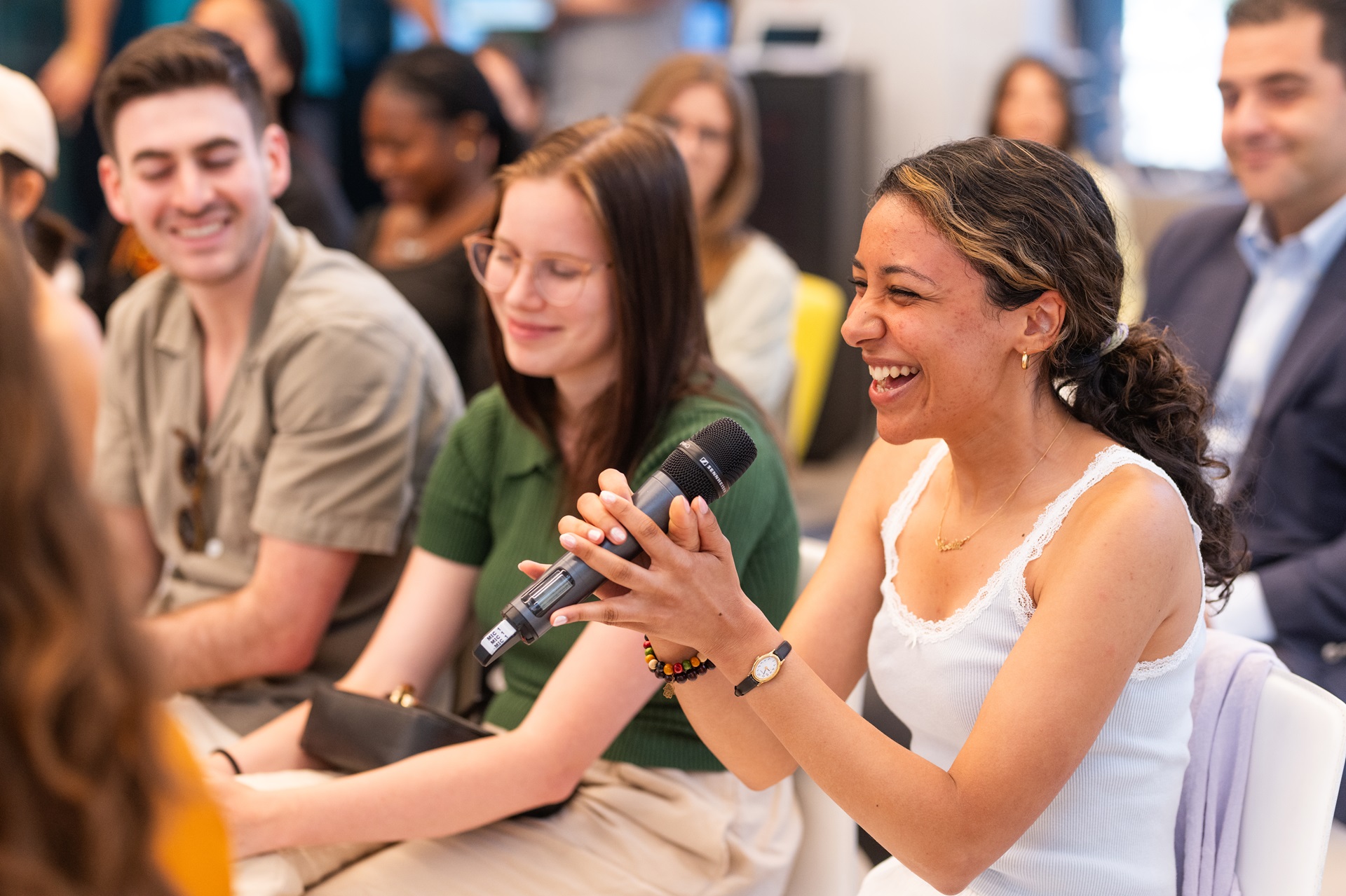 Girl holding the mic while laughing and speaking at the discussion held at the SNF headquarters.