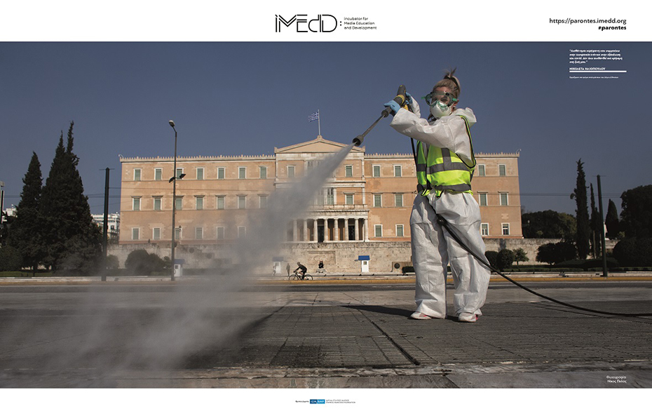 A woman in front of the Parliament building wears a special uniform and cleans the pavement with a water squeegee