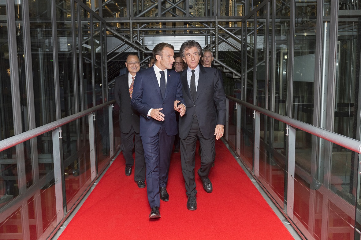 Two men, one of whom is the President of the French Republic Emmanuel Macron, walking and talking