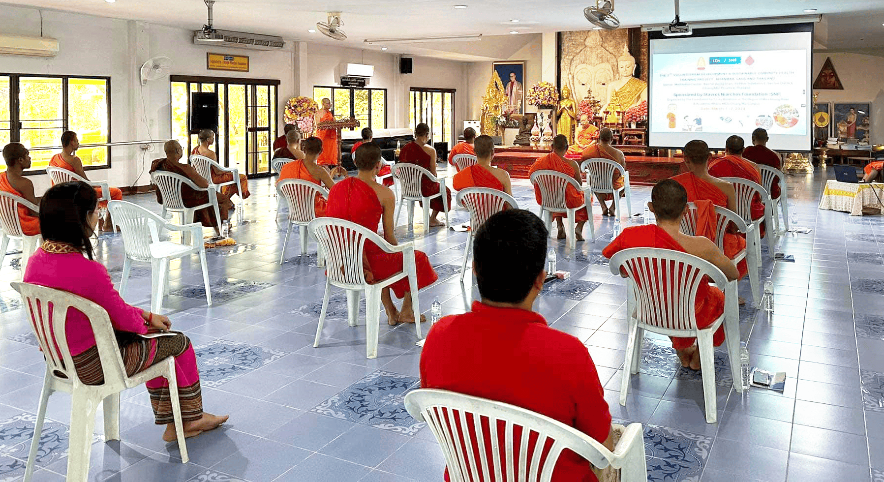 A group of people sitting in chairs during a seminar in a room.