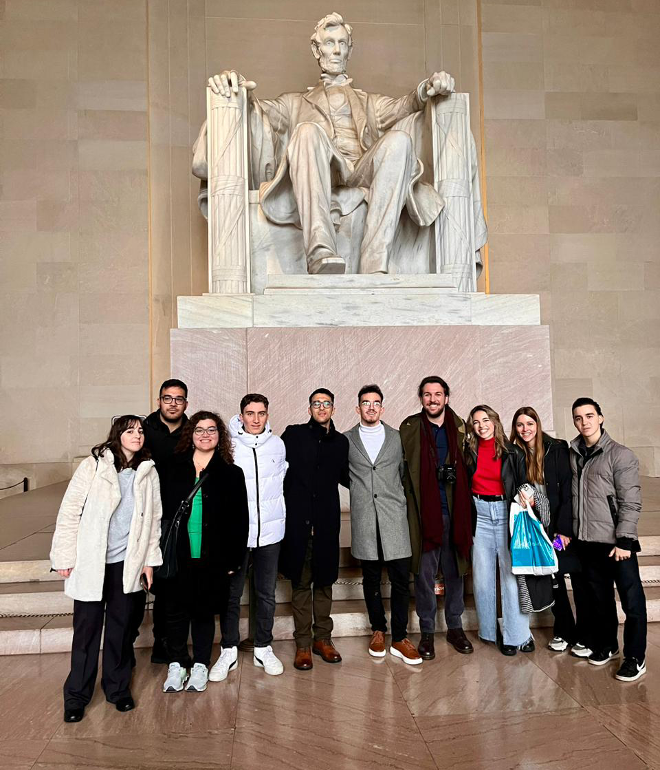 Ten students standing in front of the Lincoln Memorial, a historic monument in Washington, D.C.
