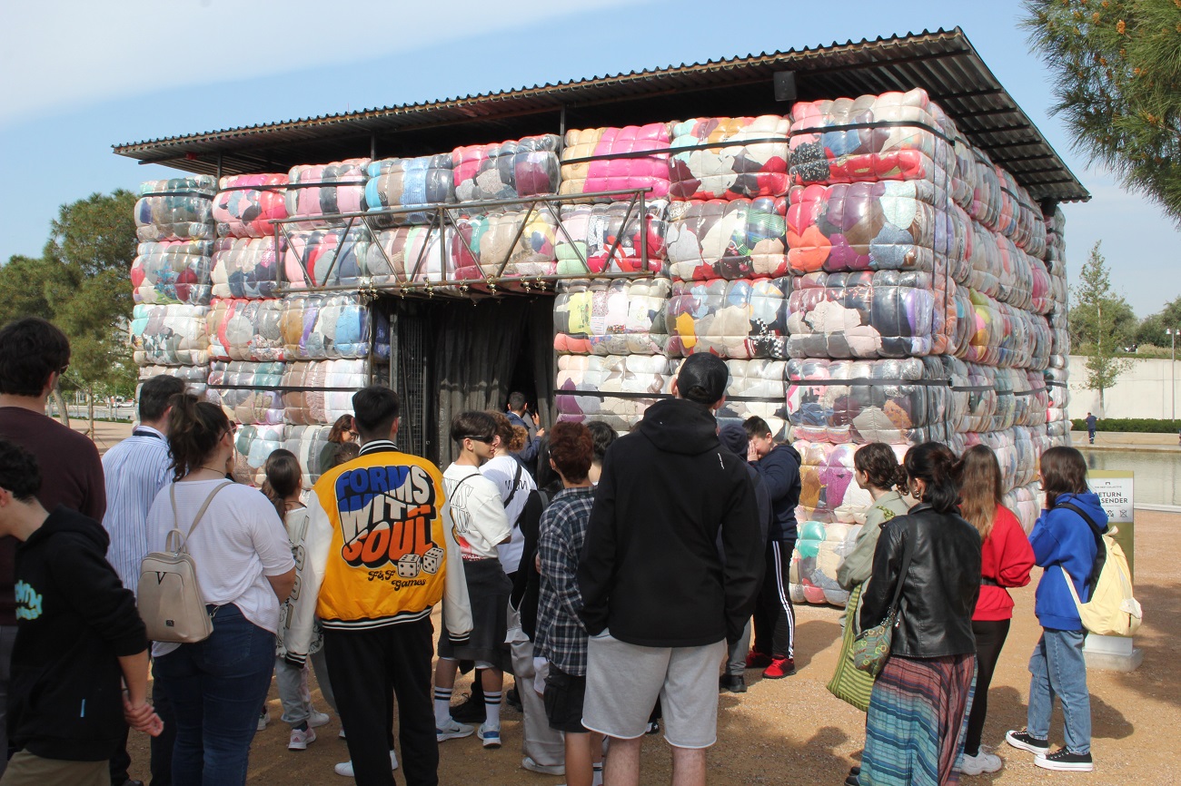 A group of students viewing the art installation Return to Sender at the SNFCC
