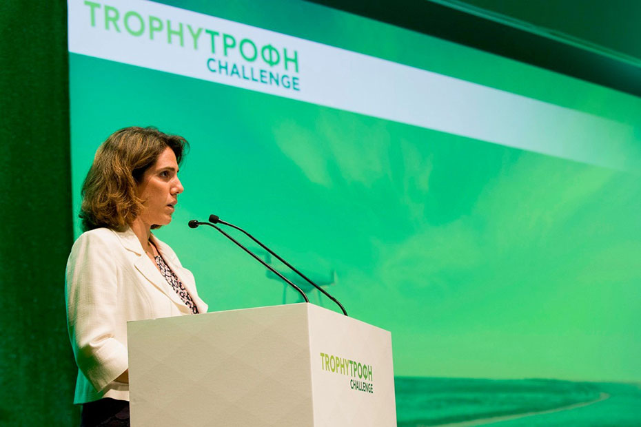 A woman gives a speech on the podium of TROPHYΤΡΟΦΗ CHALLENGE