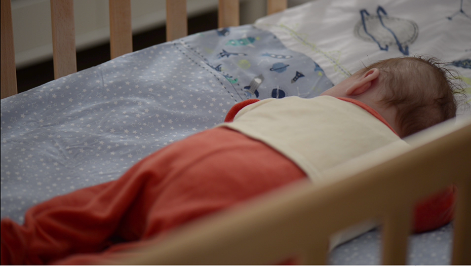 A baby sleeping in his crib