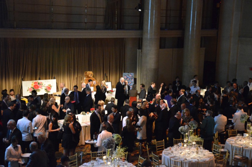 Photo taken from above showing a room with banquet tables and people walking around the tables