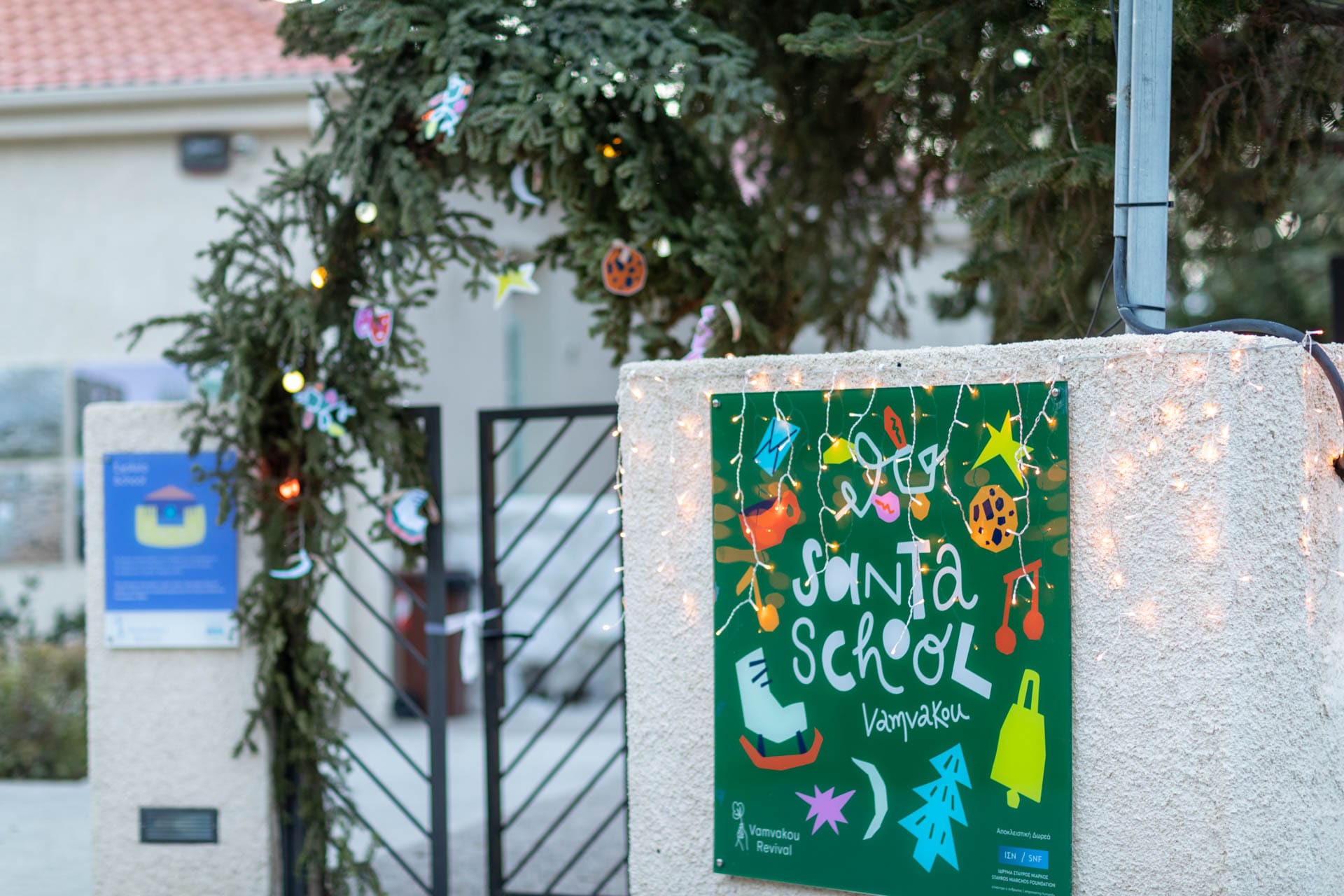 The entrance of Vamvakou Santa School, decorated with branches and Christmas lights.